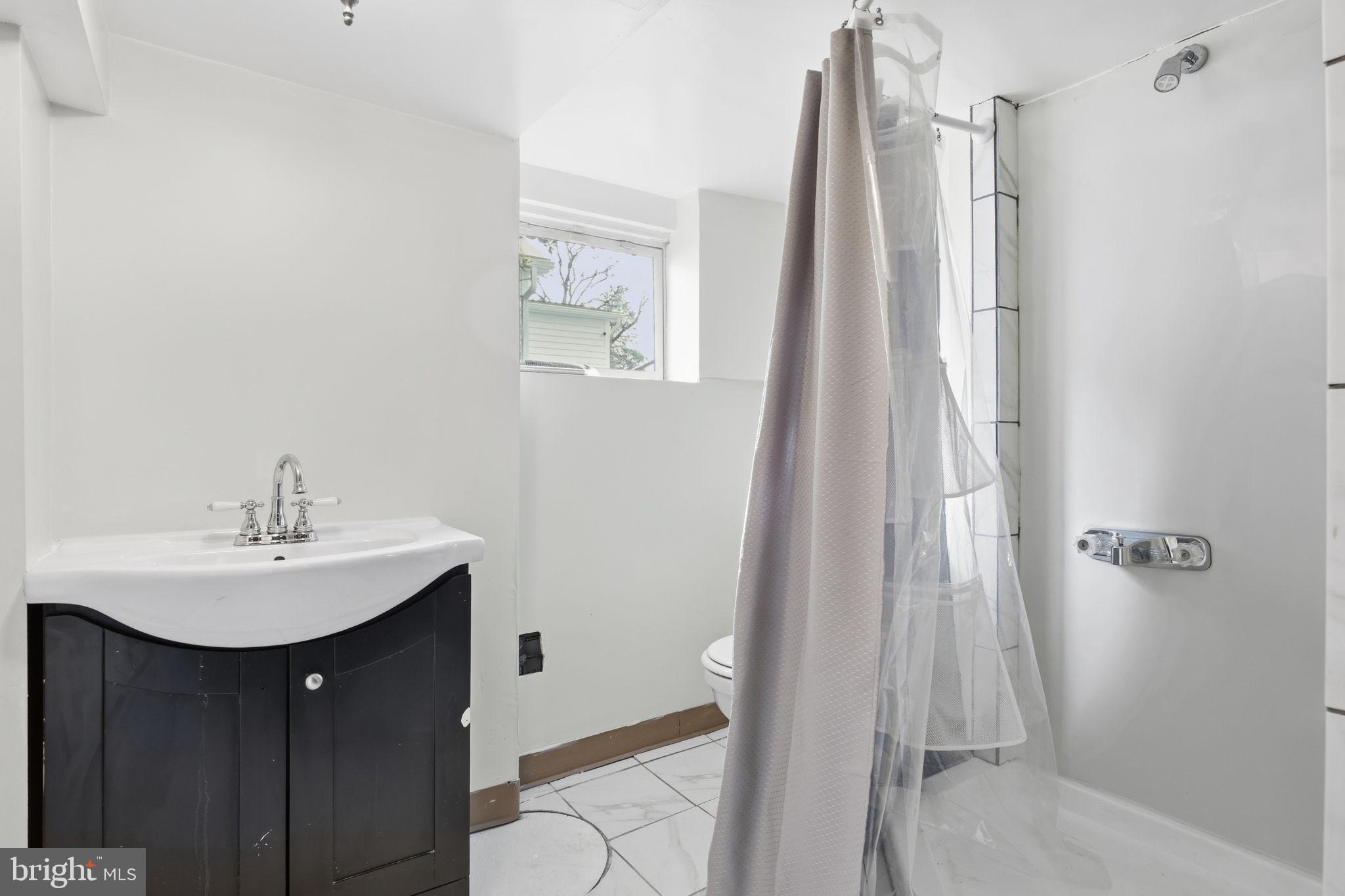 2803 Berwick Avenue Baltimore, MD 21234 - Photo 18 of 25 a bathroom with a sink a mirror a vanity and shower