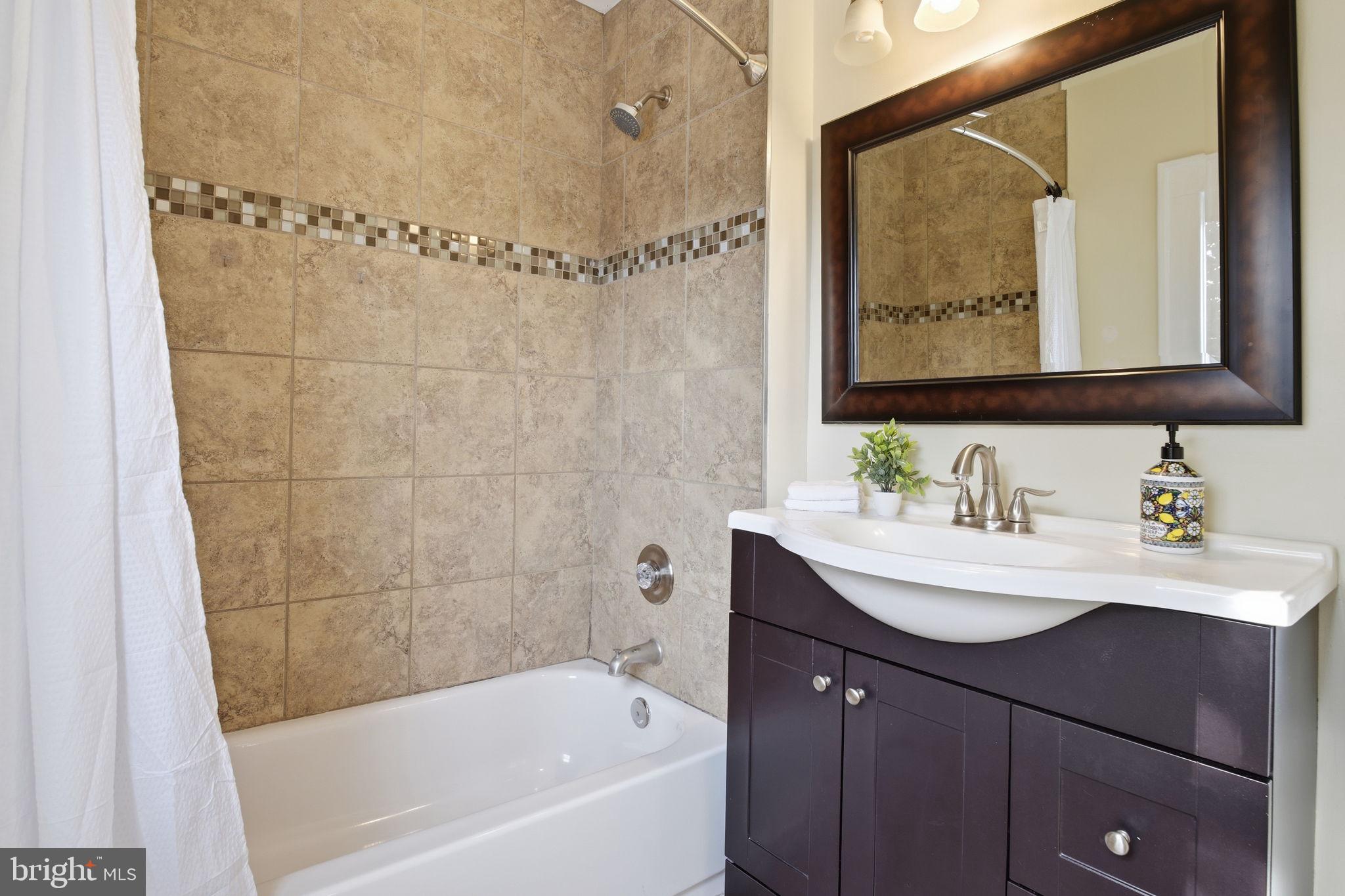 2803 Berwick Avenue Baltimore, MD 21234 - Photo 20 of 25 a bathroom with a bathtub a sink a mirror and a shower