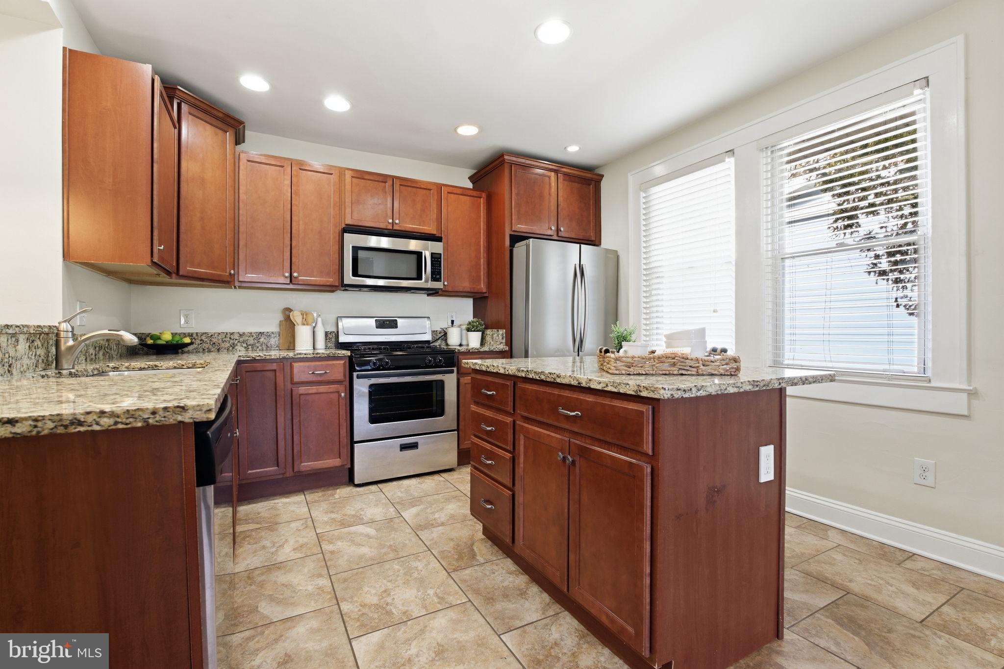 2803 Berwick Avenue Baltimore, MD 21234 - Photo 7 of 25 a kitchen with kitchen island granite countertop wooden cabinets a sink and a stove