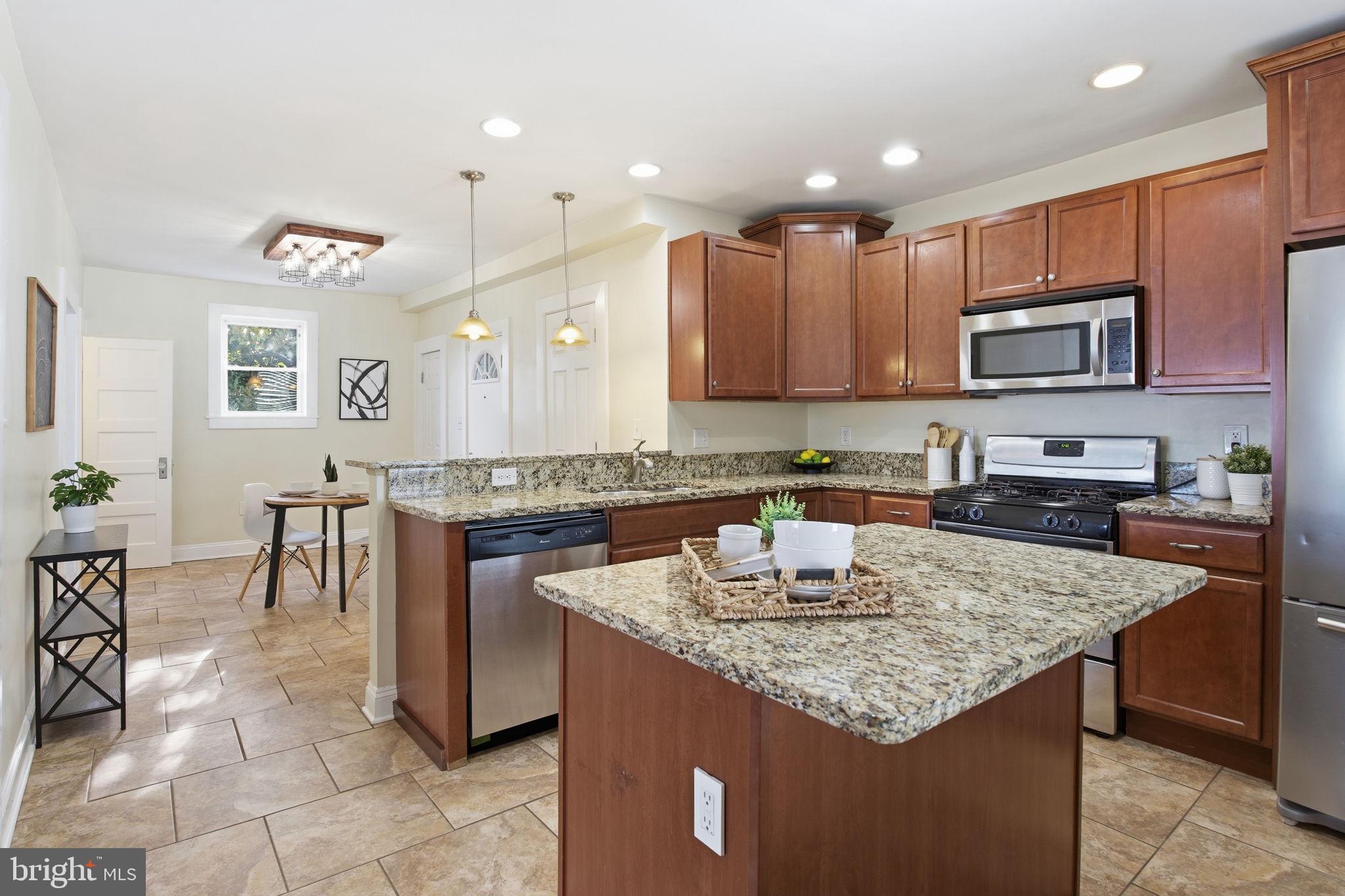 2803 Berwick Avenue Baltimore, MD 21234 - Photo 8 of 25 a kitchen with granite countertop kitchen island a stove a sink a counter top space and cabinets