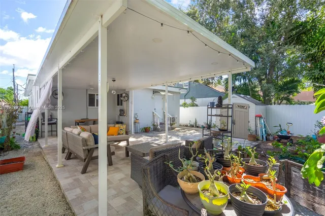 a view of a patio with chairs and potted plants