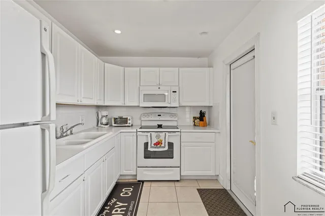 a kitchen with white cabinets and white appliances