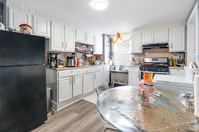 a kitchen with stainless steel appliances a stove a sink a refrigerator a center island and cabinets