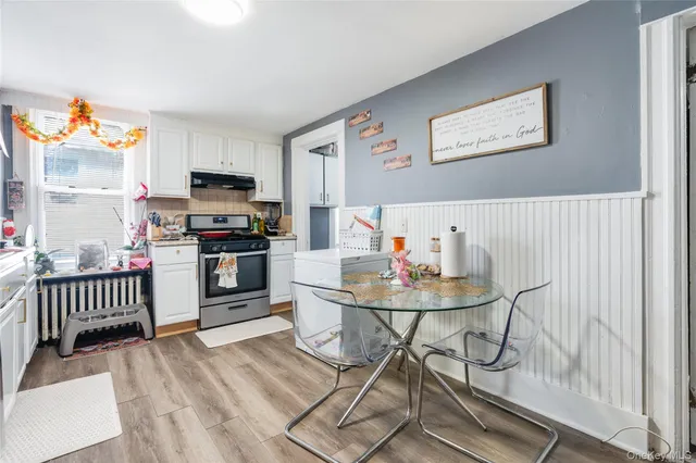 a kitchen with stainless steel appliances wooden floor dining table and chairs