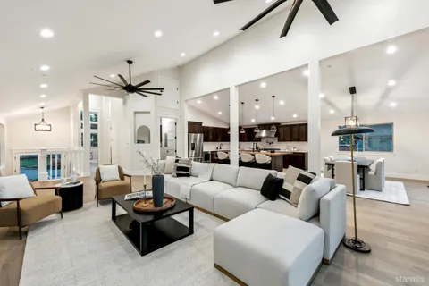 a kitchen with stainless steel appliances granite countertop a stove a sink a microwave a center island and chairs