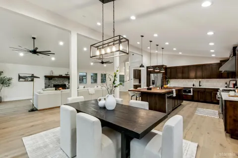 a kitchen with stainless steel appliances kitchen island granite countertop a sink a stove a dining table and chairs