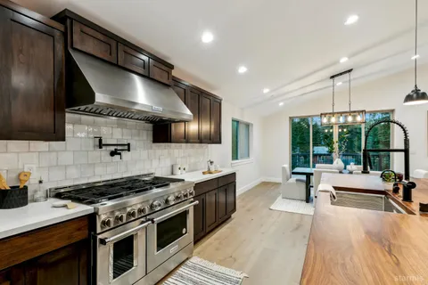 a kitchen with stainless steel appliances a stove sink and wooden floor