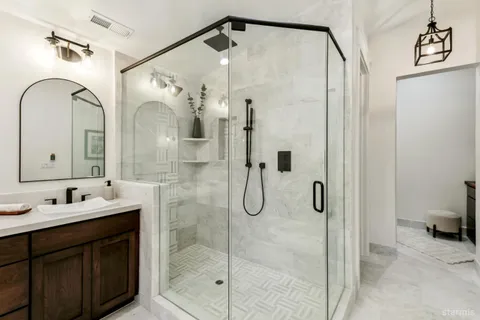 a bathroom with a double vanity sink mirror and shower