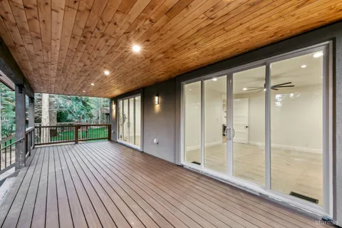 a view of hallway with a large window and wooden floor