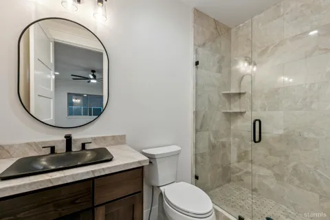 a bathroom with a sink a toilet and a mirror