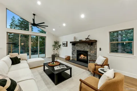 a living room with furniture large window and fireplace
