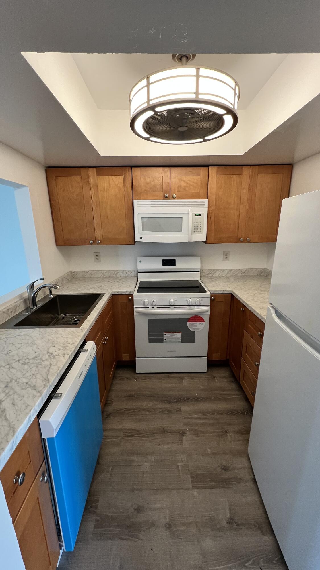 1860 Robalo Drive, Unit 104 Vero Beach, FL 32960 - Photo 6 of 11 a kitchen with stainless steel appliances granite countertop a sink a stove and a microwave