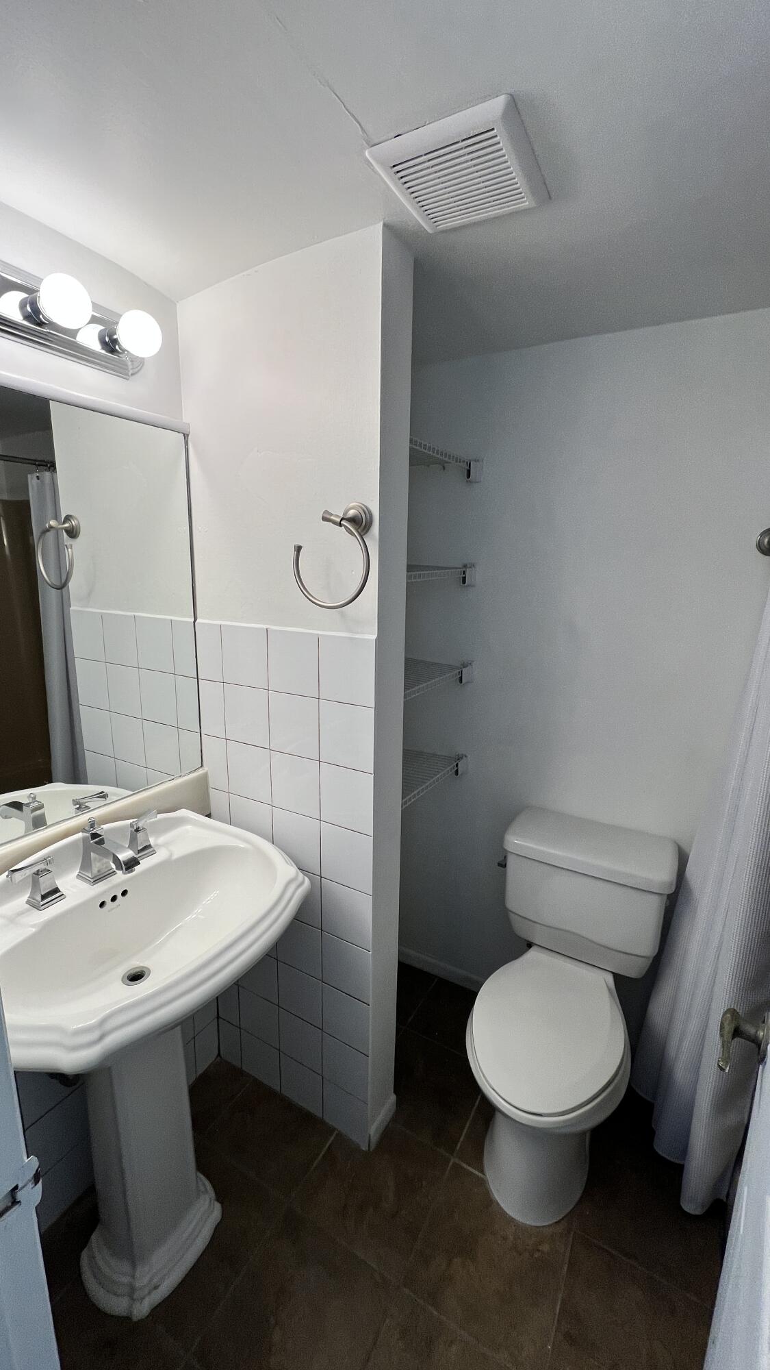 1860 Robalo Drive, Unit 104 Vero Beach, FL 32960 - Photo 8 of 11 a bathroom with a sink a toilet and shower