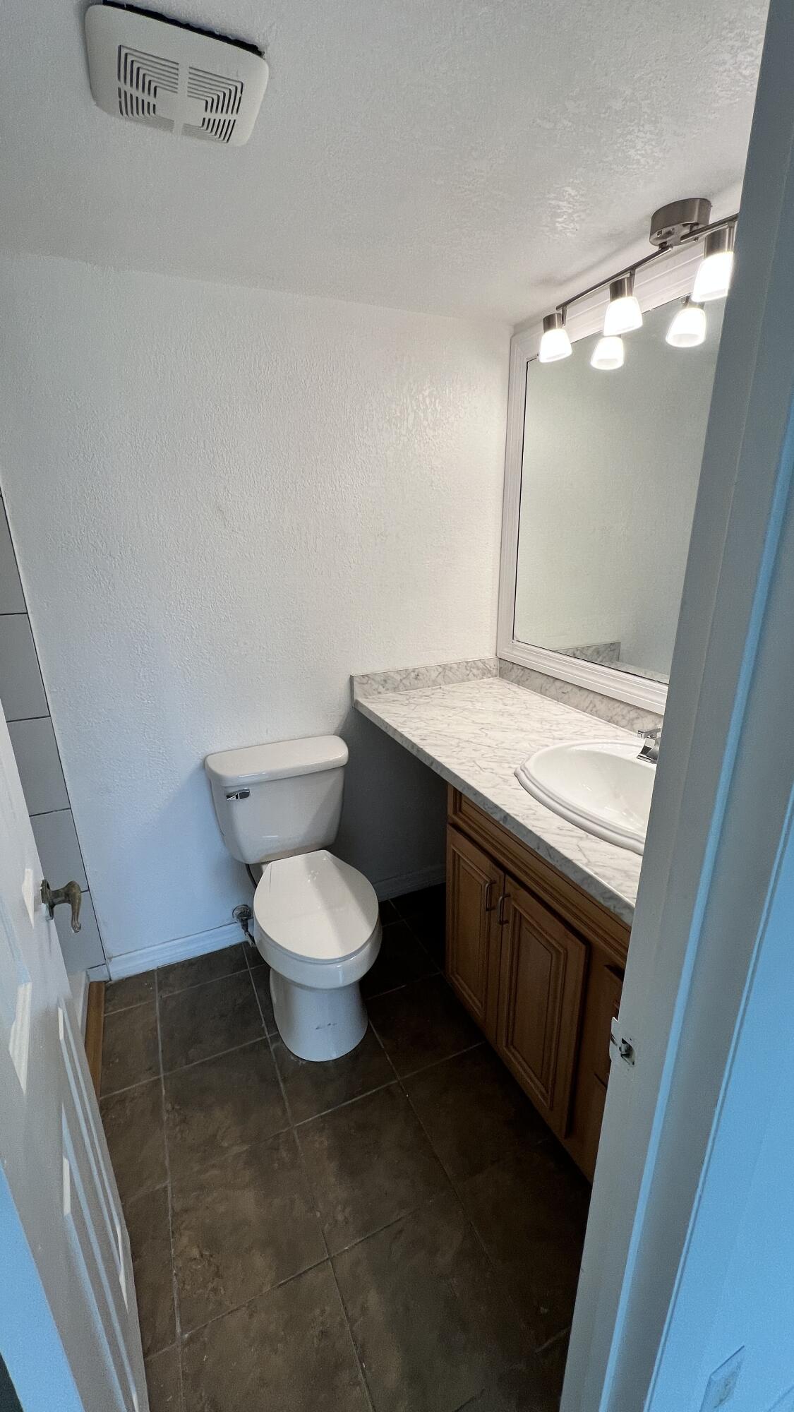 1860 Robalo Drive, Unit 104 Vero Beach, FL 32960 - Photo 9 of 11 a bathroom with a toilet a sink and mirror