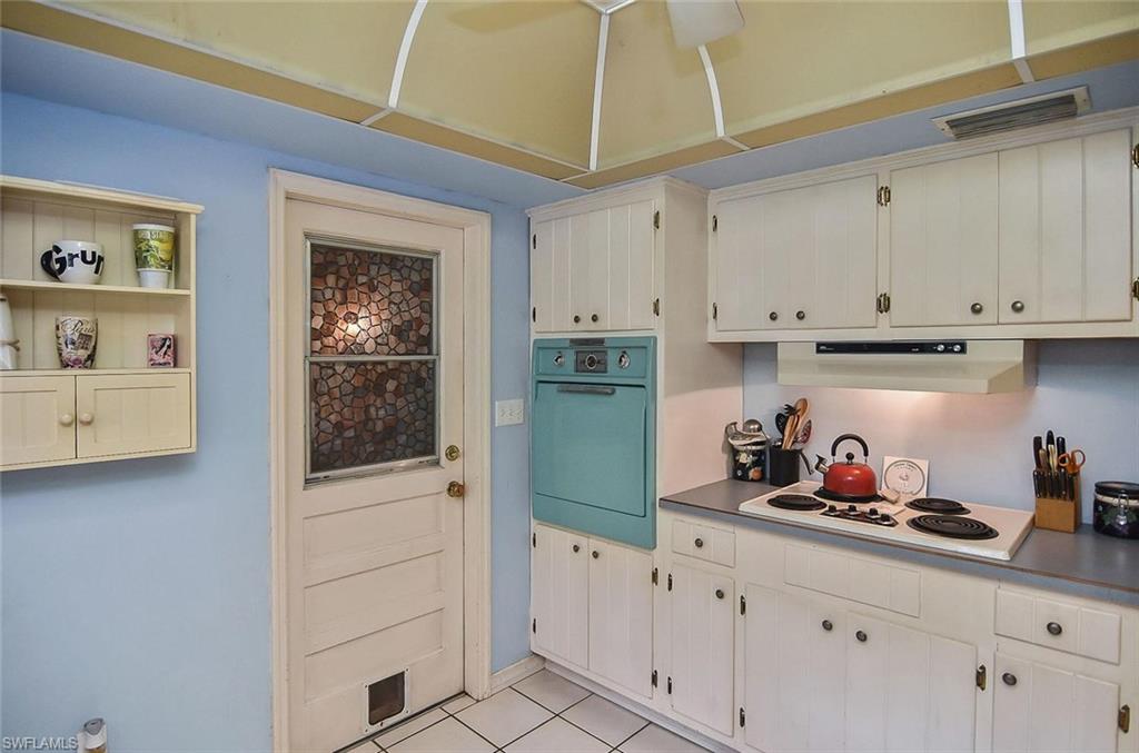 1431 Collins Road Fort Myers, FL 33919 - Photo 18 of 30 a kitchen with white cabinets and window