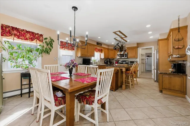 a kitchen with stainless steel appliances kitchen island granite countertop a table and chairs in it