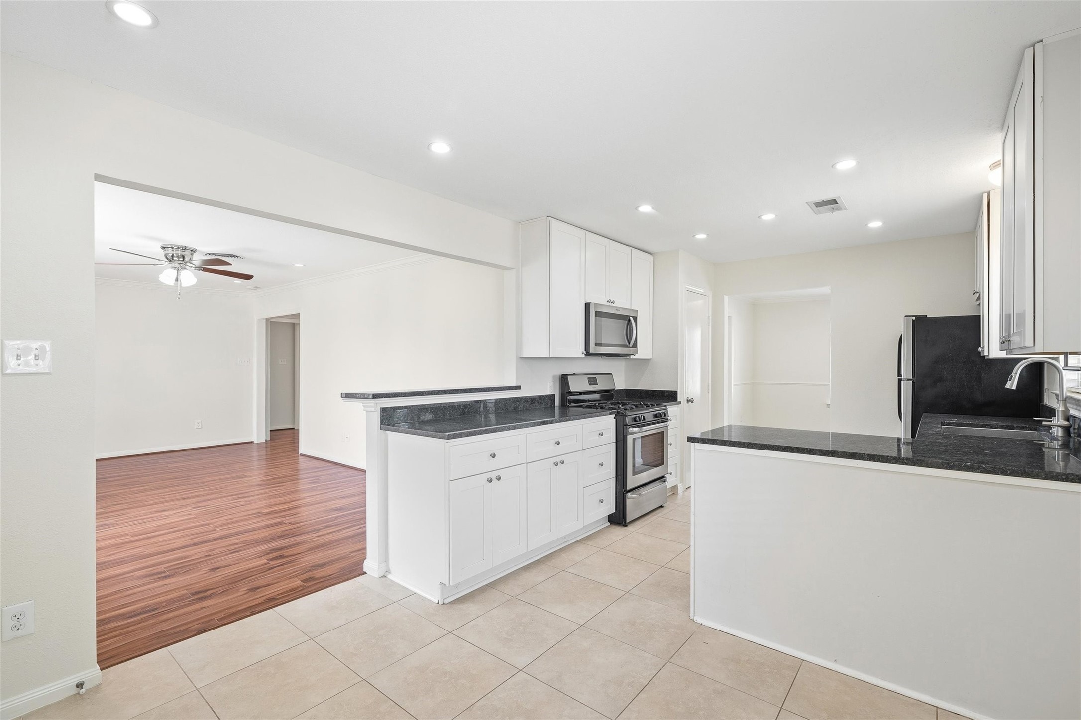 3331 Arbor Street Houston, TX 77004 - Photo 10 of 30 The space opens to a room with warm wood flooring and a ceiling fan, providing a bright and inviting atmosphere.