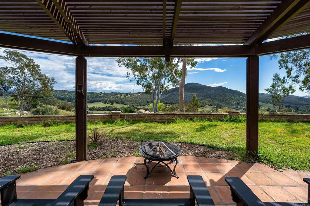 26086 Bear Valley Heights Road Valley Center, CA 92082 - Photo 47 of 65 a view of a patio with a table chairs and backyard