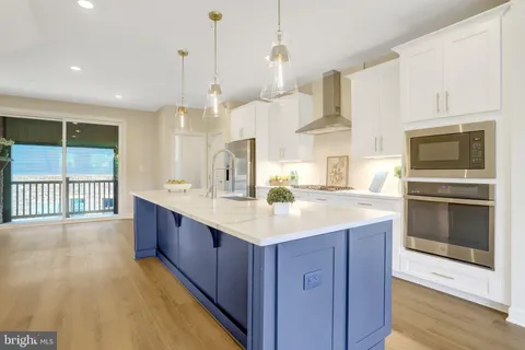 a kitchen with kitchen island granite countertop a sink appliances and cabinets