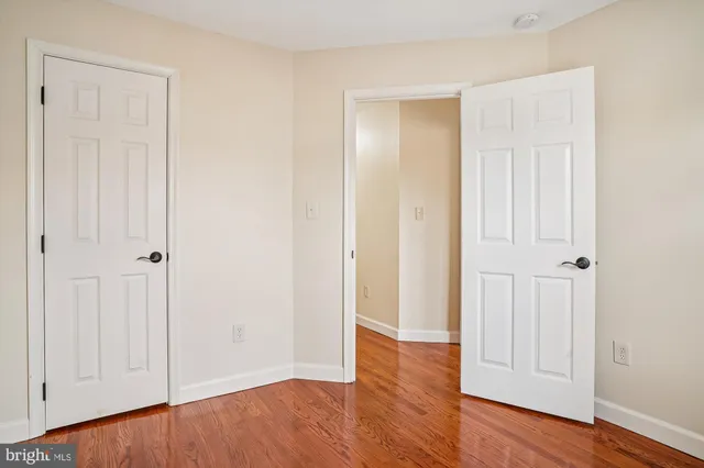 an empty room with wooden floor & closet area
