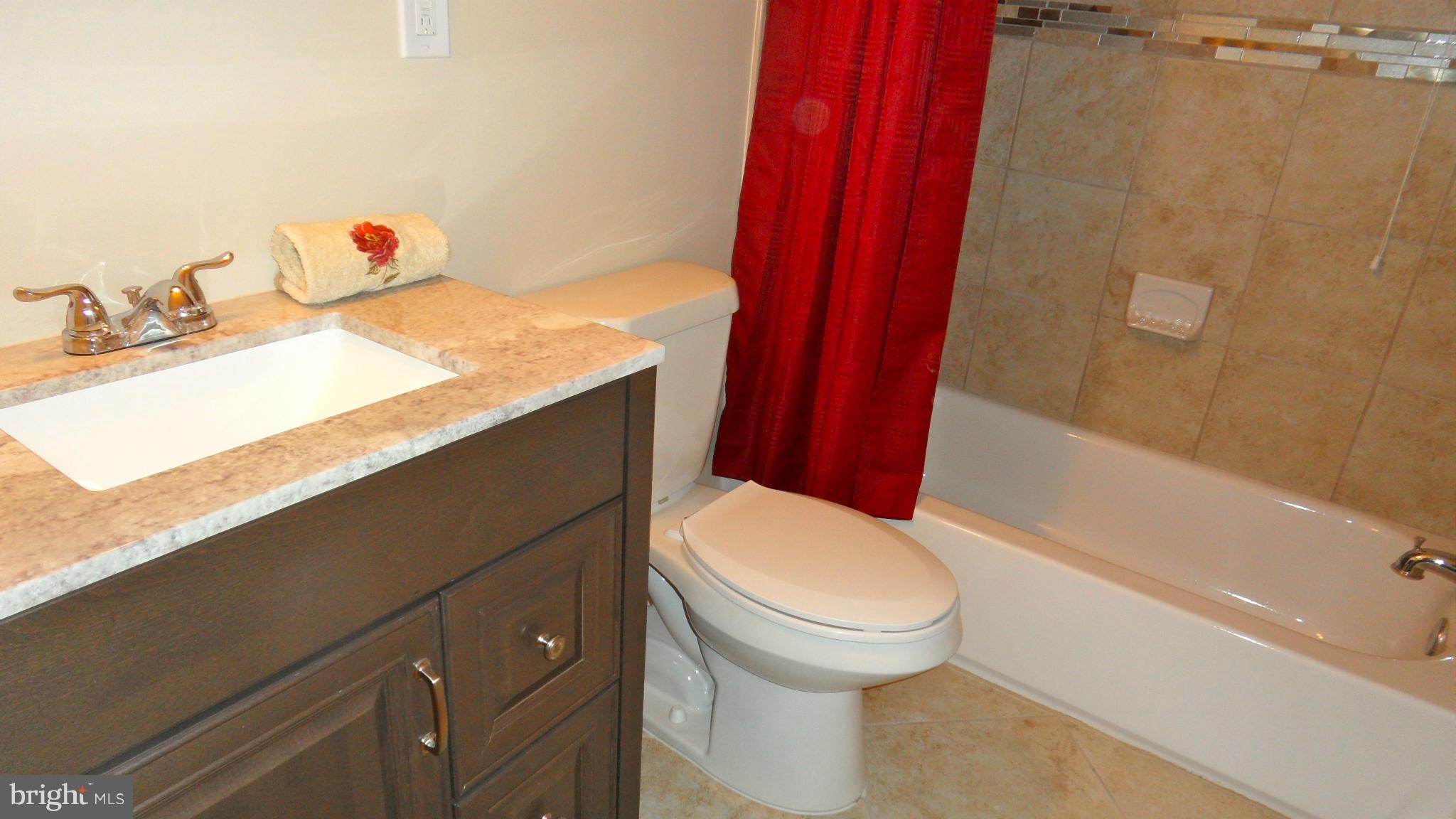 7413 Sudbrook Road Baltimore, MD 21208 - Photo 13 of 30 a bathroom with a sink a toilet and shower