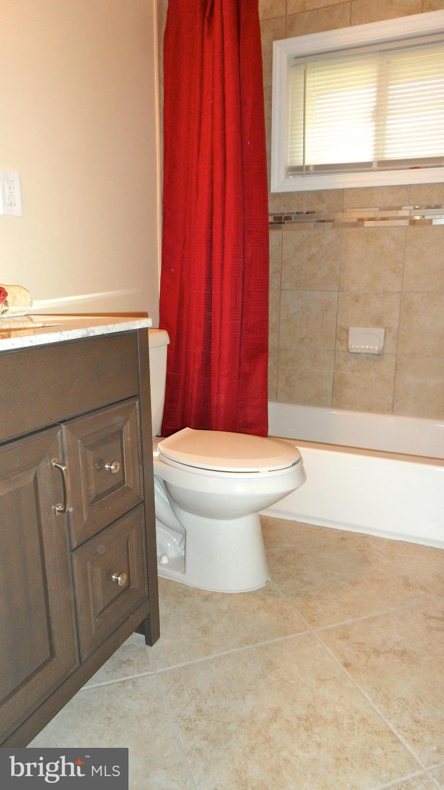 7413 Sudbrook Road Baltimore, MD 21208 - Photo 14 of 30 a bathroom with a toilet a sink and a shower