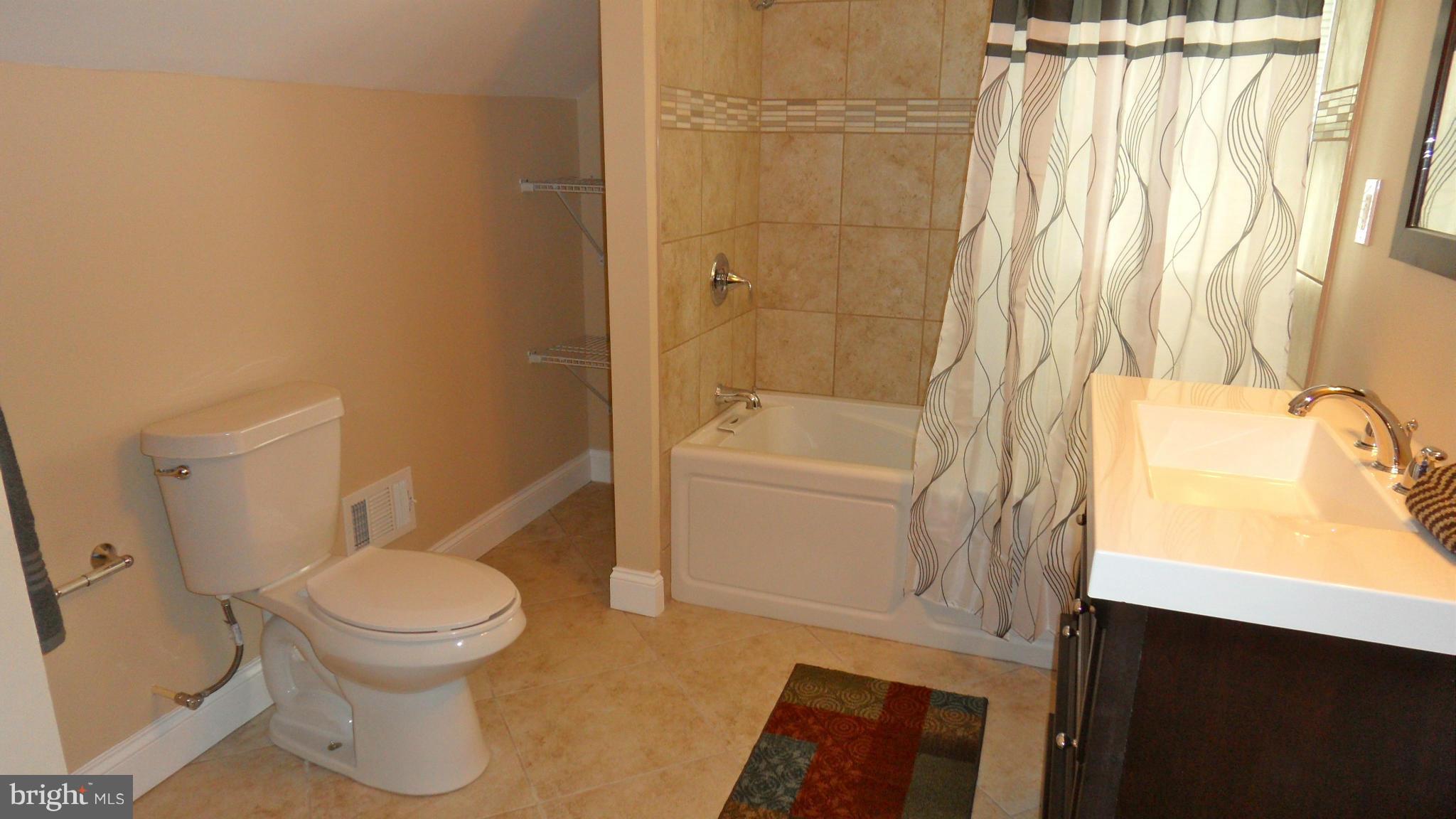 7413 Sudbrook Road Baltimore, MD 21208 - Photo 17 of 30 a white toilet sitting next to a bathroom sink and tub