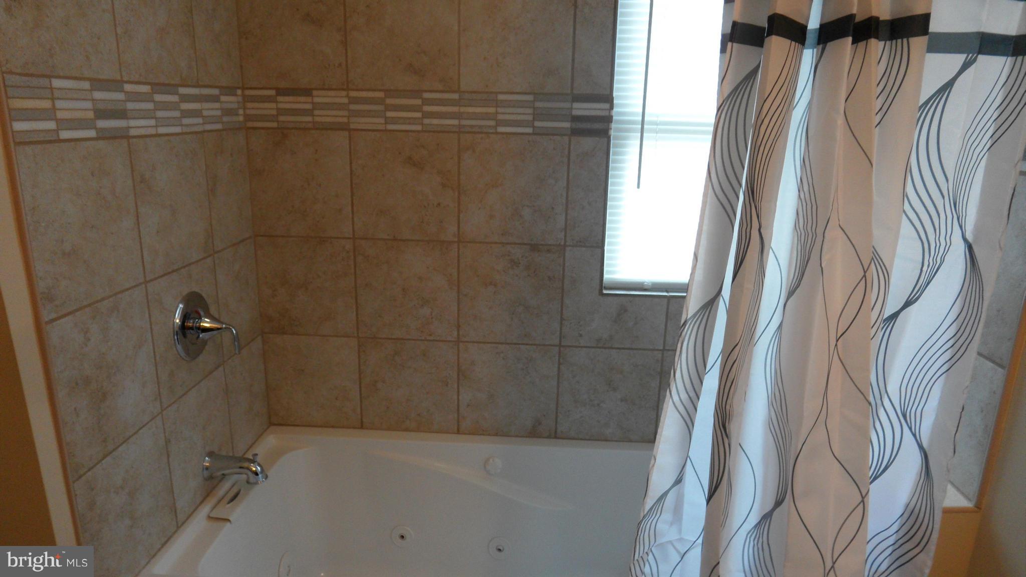 7413 Sudbrook Road Baltimore, MD 21208 - Photo 18 of 30 a bathroom with a shower and a bathtub