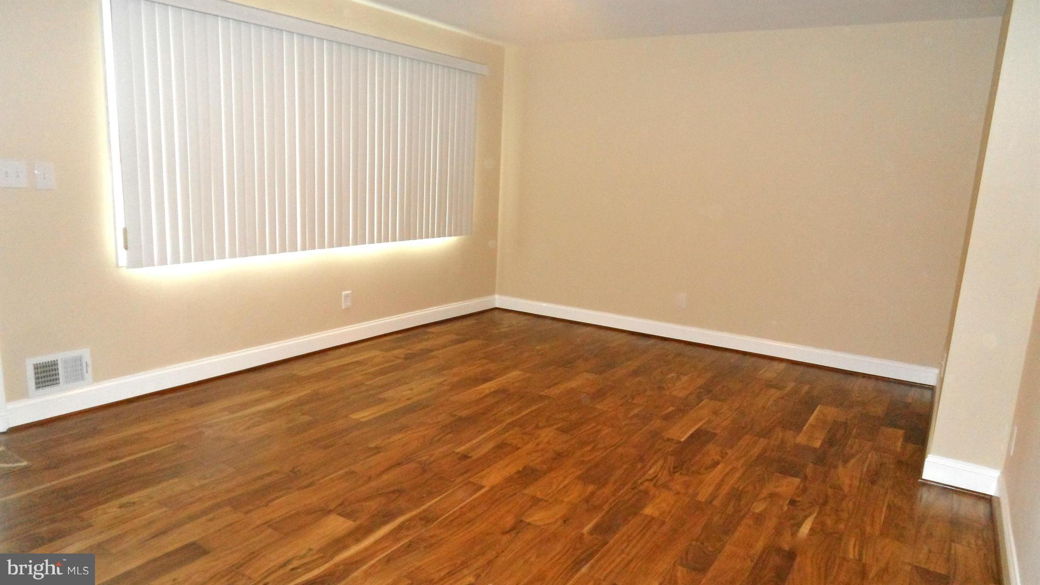 7413 Sudbrook Road Baltimore, MD 21208 - Photo 4 of 30 an empty room with wooden floor and windows