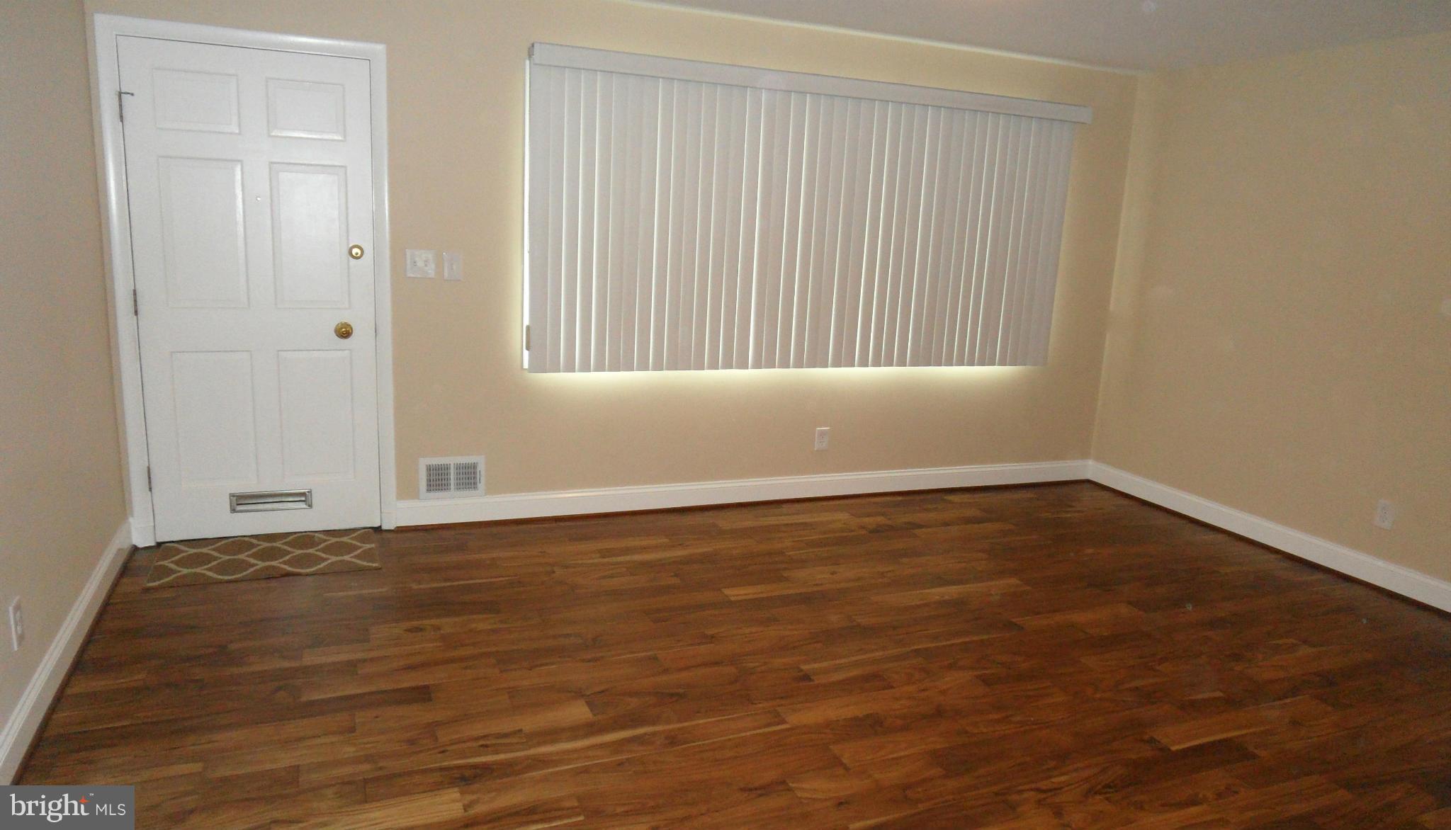 7413 Sudbrook Road Baltimore, MD 21208 - Photo 5 of 30 a view of an empty room with wooden floor and a window