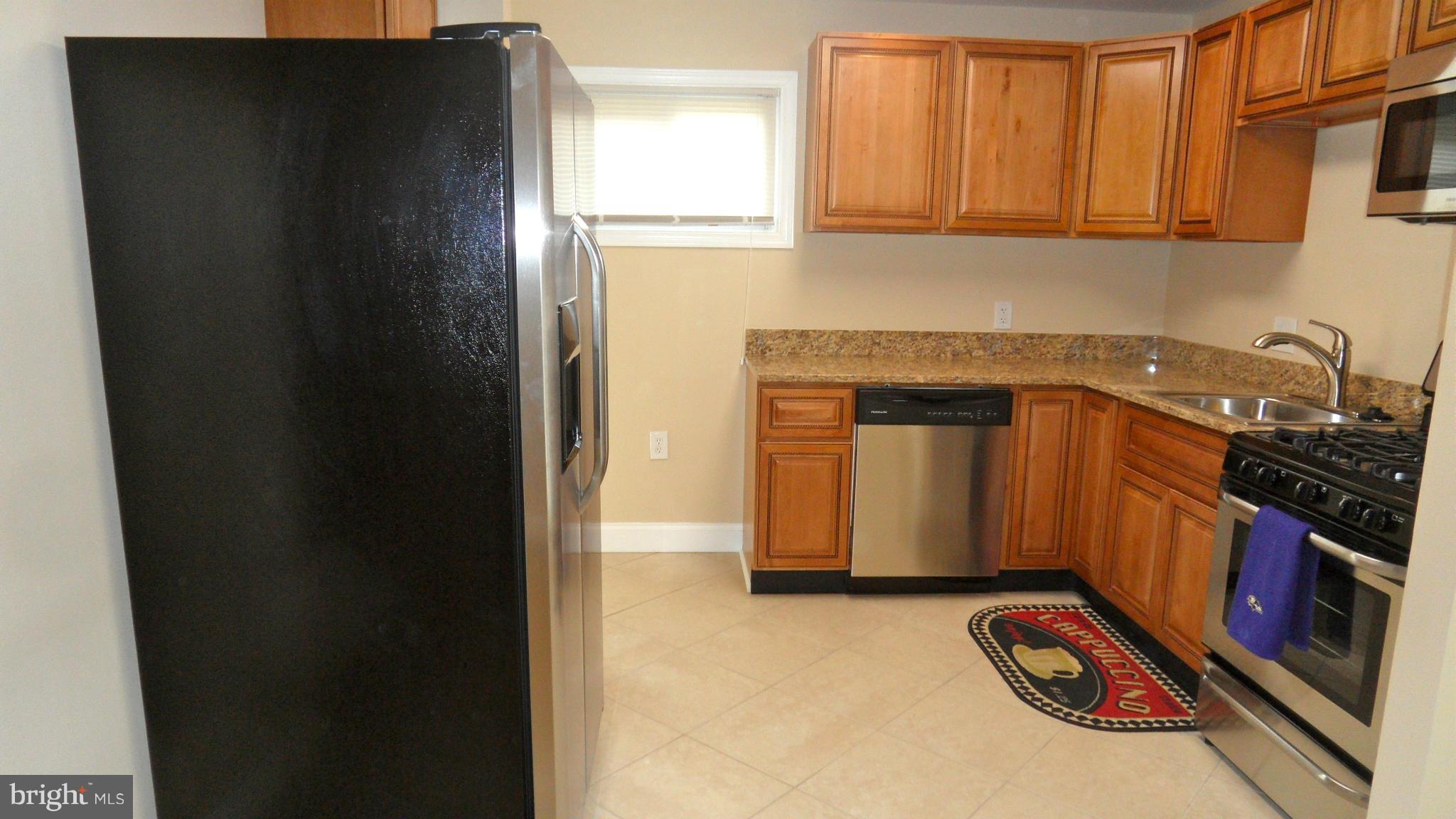 7413 Sudbrook Road Baltimore, MD 21208 - Photo 6 of 30 a kitchen with granite countertop a refrigerator stove and cabinets