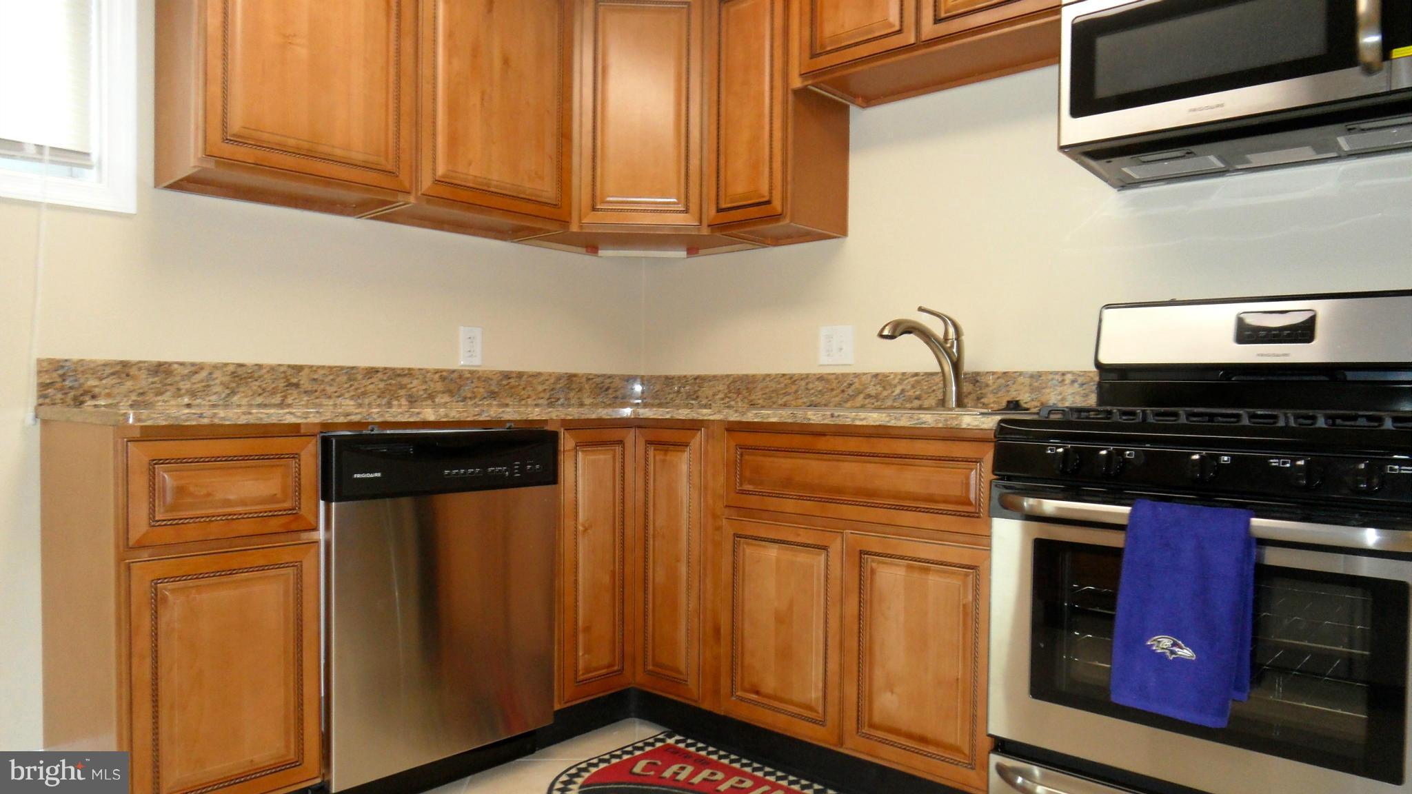 7413 Sudbrook Road Baltimore, MD 21208 - Photo 7 of 30 a kitchen with stainless steel appliances granite countertop a stove and a microwave