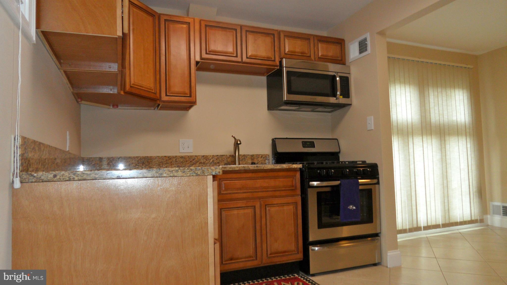 7413 Sudbrook Road Baltimore, MD 21208 - Photo 8 of 30 a kitchen with stainless steel appliances granite countertop a stove and a microwave