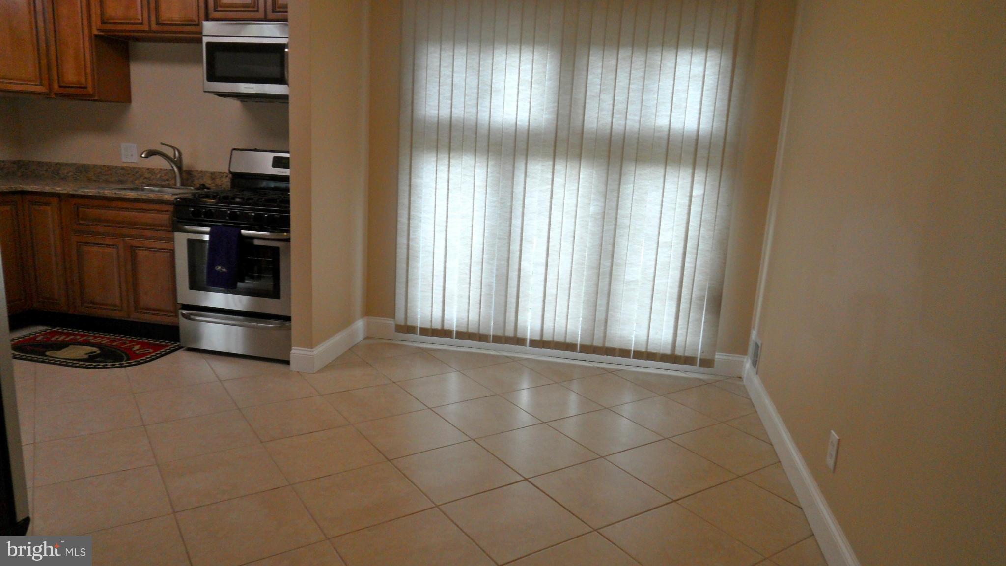 7413 Sudbrook Road Baltimore, MD 21208 - Photo 10 of 30 an empty room with wooden floor and windows