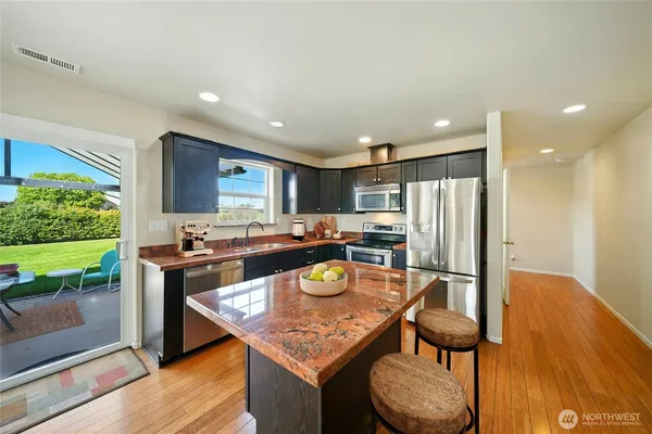 a kitchen with stainless steel appliances granite countertop a sink and a refrigerator