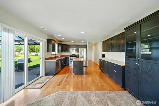 a large kitchen with stainless steel appliances granite countertop a large counter top a stove and a refrigerator