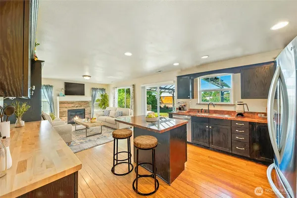 a kitchen with stainless steel appliances granite countertop a stove a sink dishwasher and cabinets with wooden floor