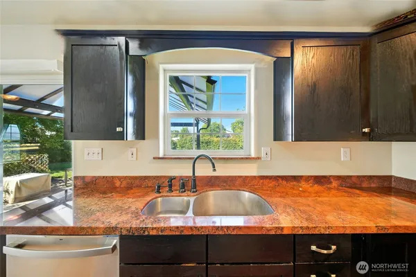 a bathroom with a granite countertop sink and a large mirror