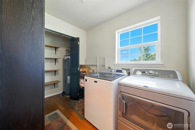 a view of washer and dryer with bathroom in the background
