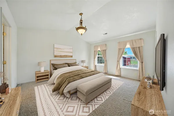 a bedroom with a bed and a flat tv screen on dresser