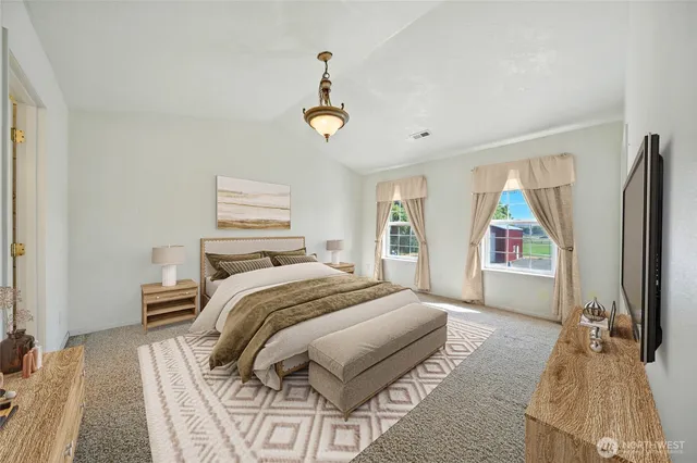 a bedroom with a bed and a flat tv screen on dresser