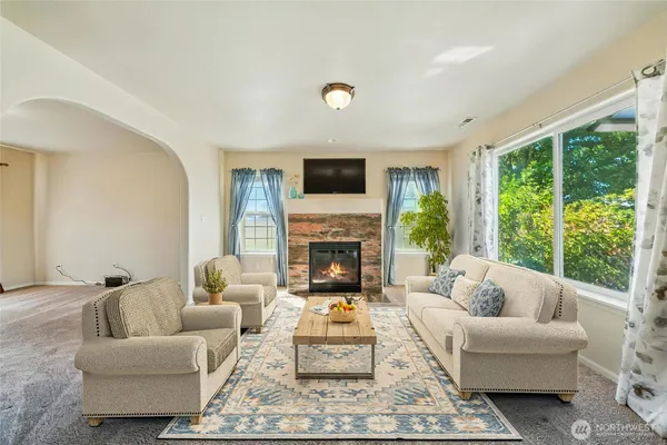 a living room with furniture a fireplace and a flat screen tv