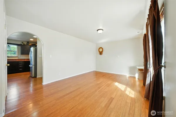 an empty room with wooden floor and a bathroom
