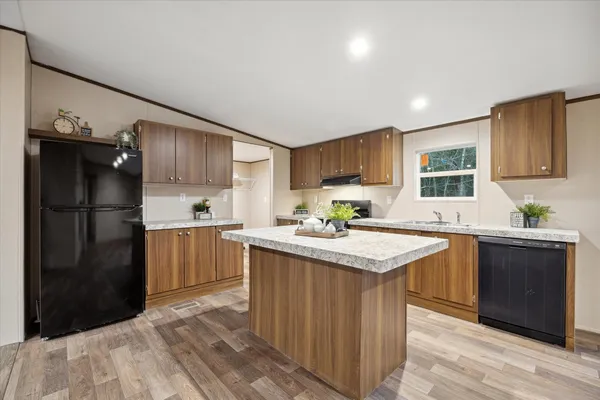 a kitchen with a refrigerator a sink dishwasher and a stove with wooden floor