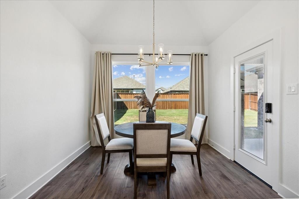 1710 Highwood Road Forney, TX 75126 - Photo 13 of 25 Dining space featuring wood-finish flooring, a contemporary chandelier, and a large window with drapes