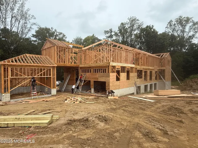 a front view of a house with large trees