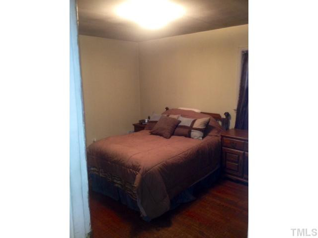 524 Cooper Road Raleigh, NC 27610 - Photo 7 of 12 a bed sitting in a bedroom next to a bathroom