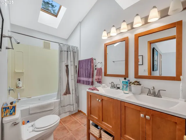 a bathroom with a granite countertop sink toilet mirror and shower