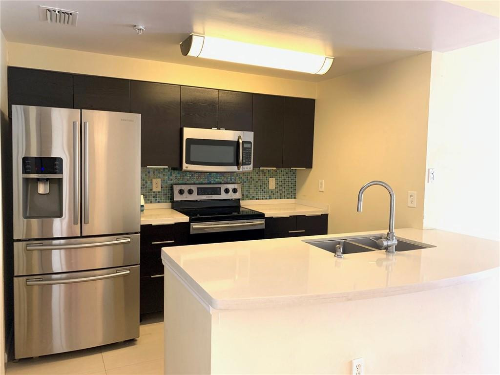 5980 West Sample Road, Unit 303 Coral Springs, FL 33067 - Photo 1 of 32 a kitchen with stainless steel appliances a refrigerator and a stove top oven