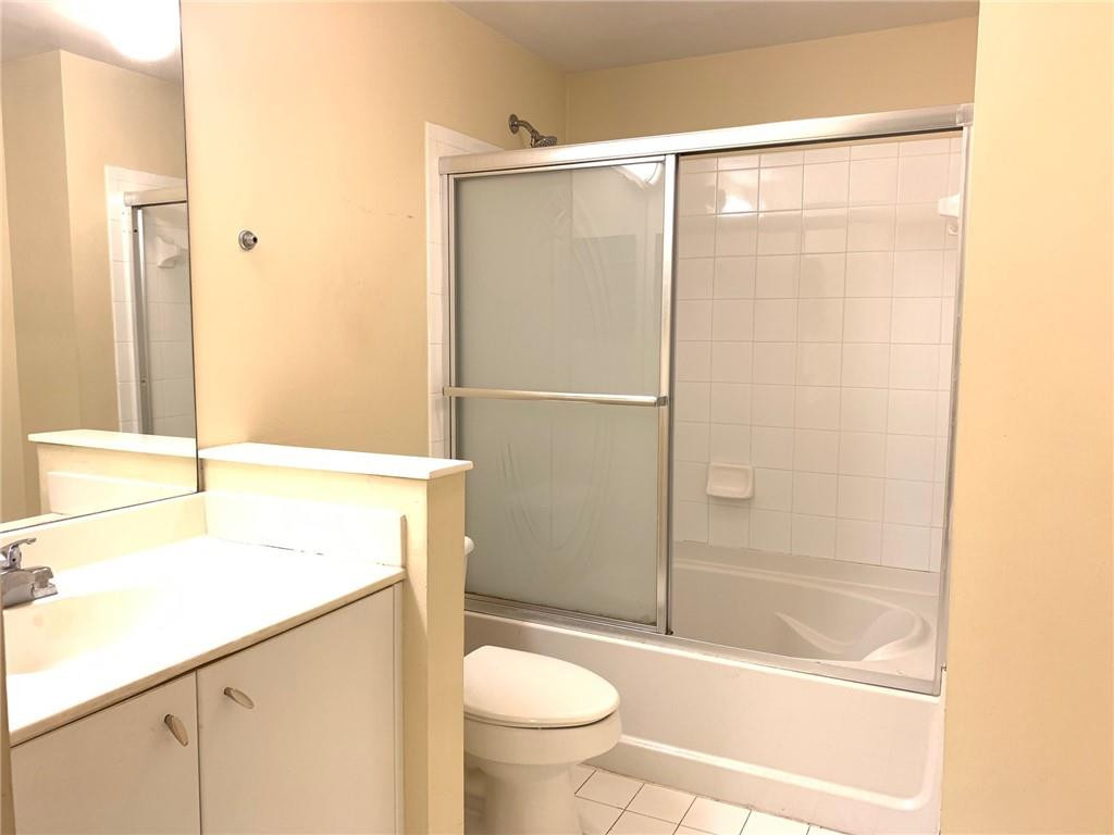 5980 West Sample Road, Unit 303 Coral Springs, FL 33067 - Photo 17 of 32 a bathroom with a granite countertop sink toilet and shower